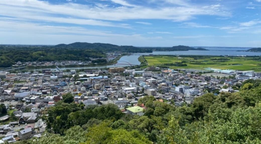 山の上から眺めた町と田園風景。青空と広がる景色